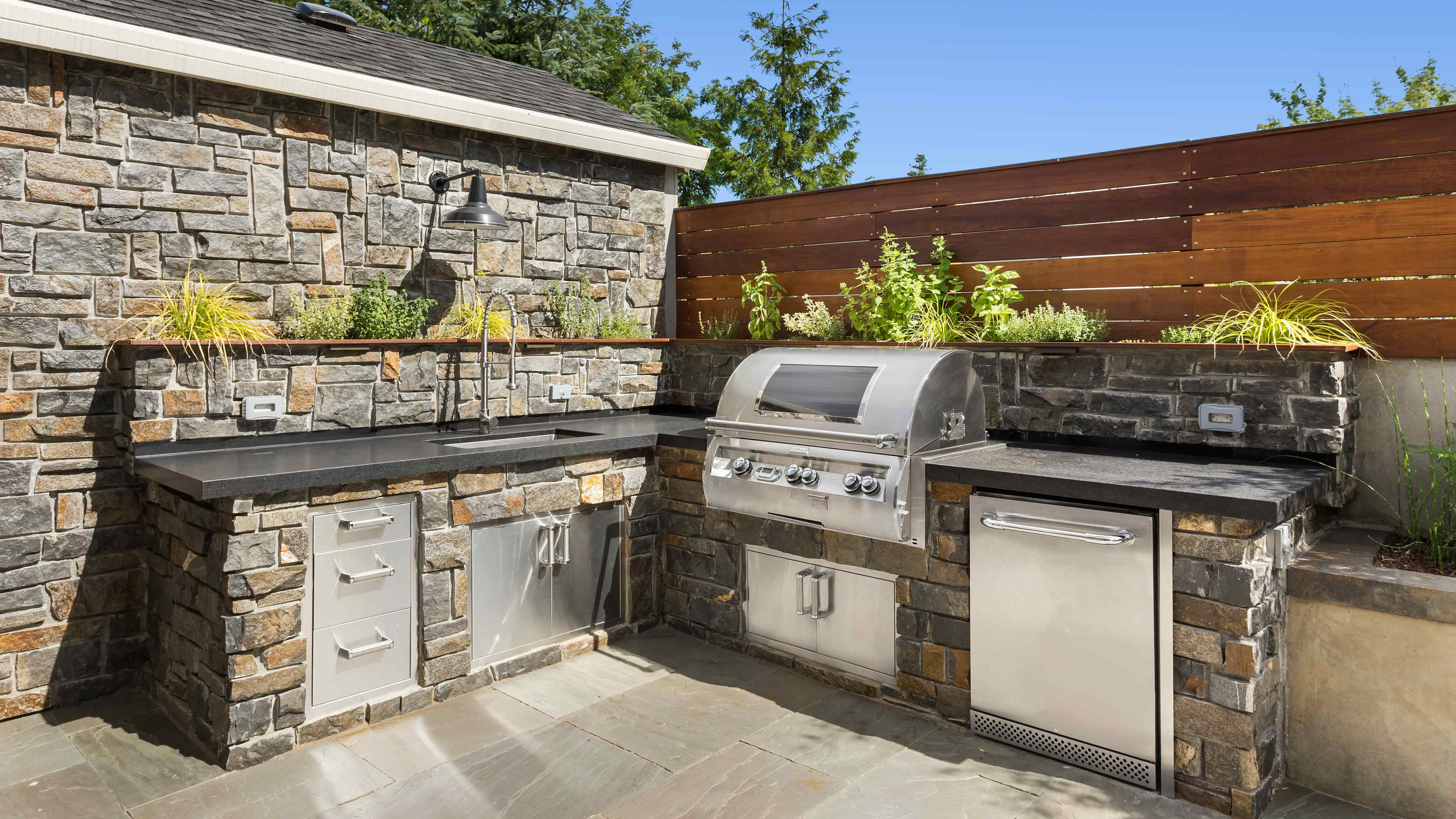 Outdoor kitchen with stainless steel sink and BBQ grill  