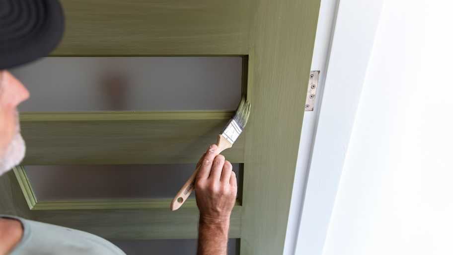 Man painting front door.