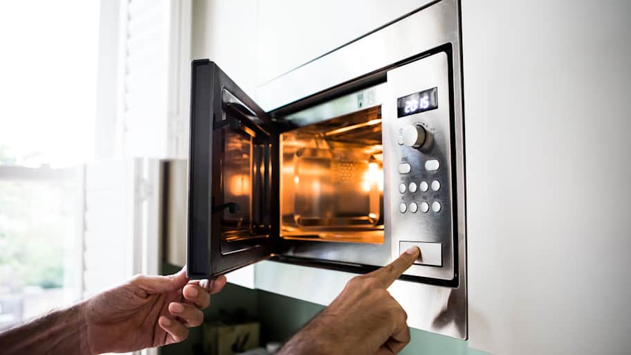 A man using a microwave oven