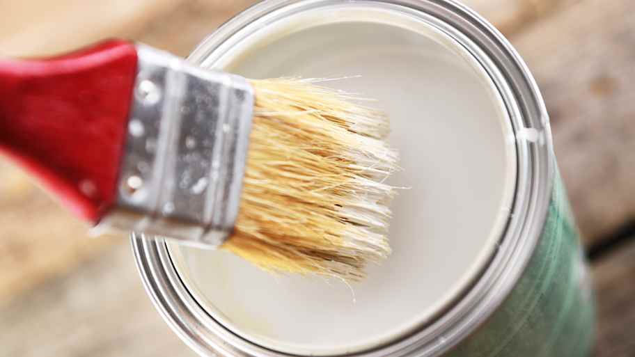 The paintbrush was being dipped into a jar of paint