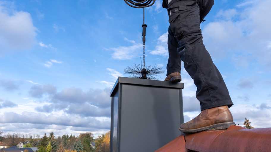 A professional sweeping a chimney