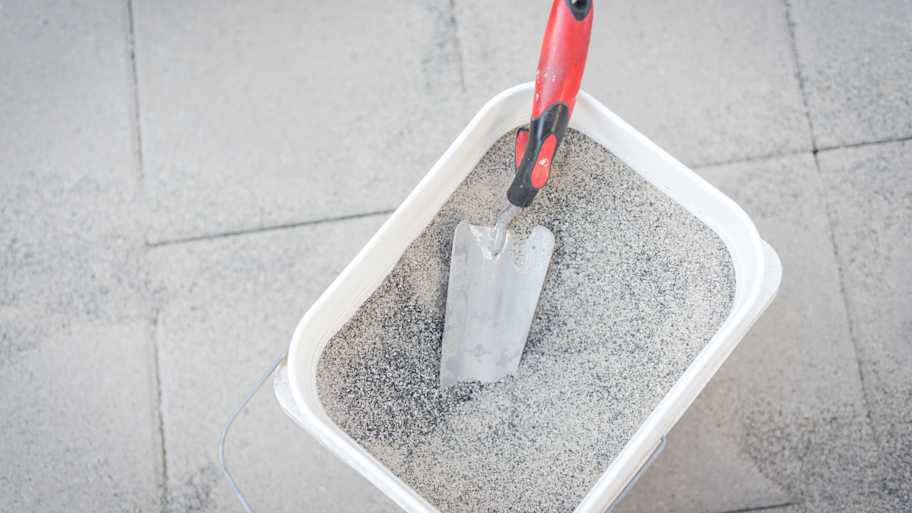 Bucket of polymeric paver sand