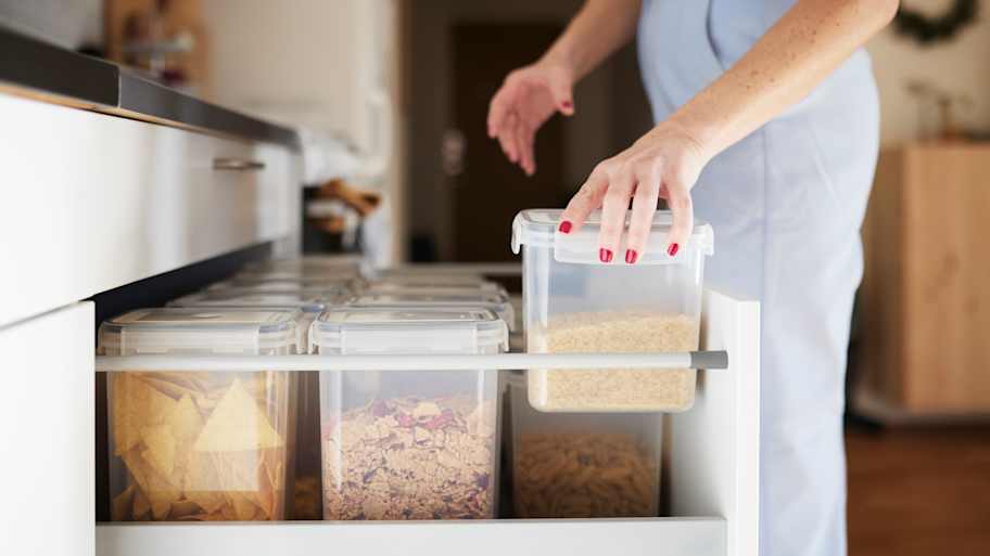 A woman organizing a kitchen drawer