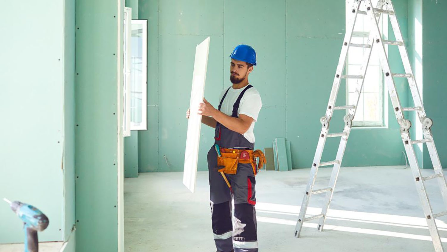 Person installing panel in green painted room