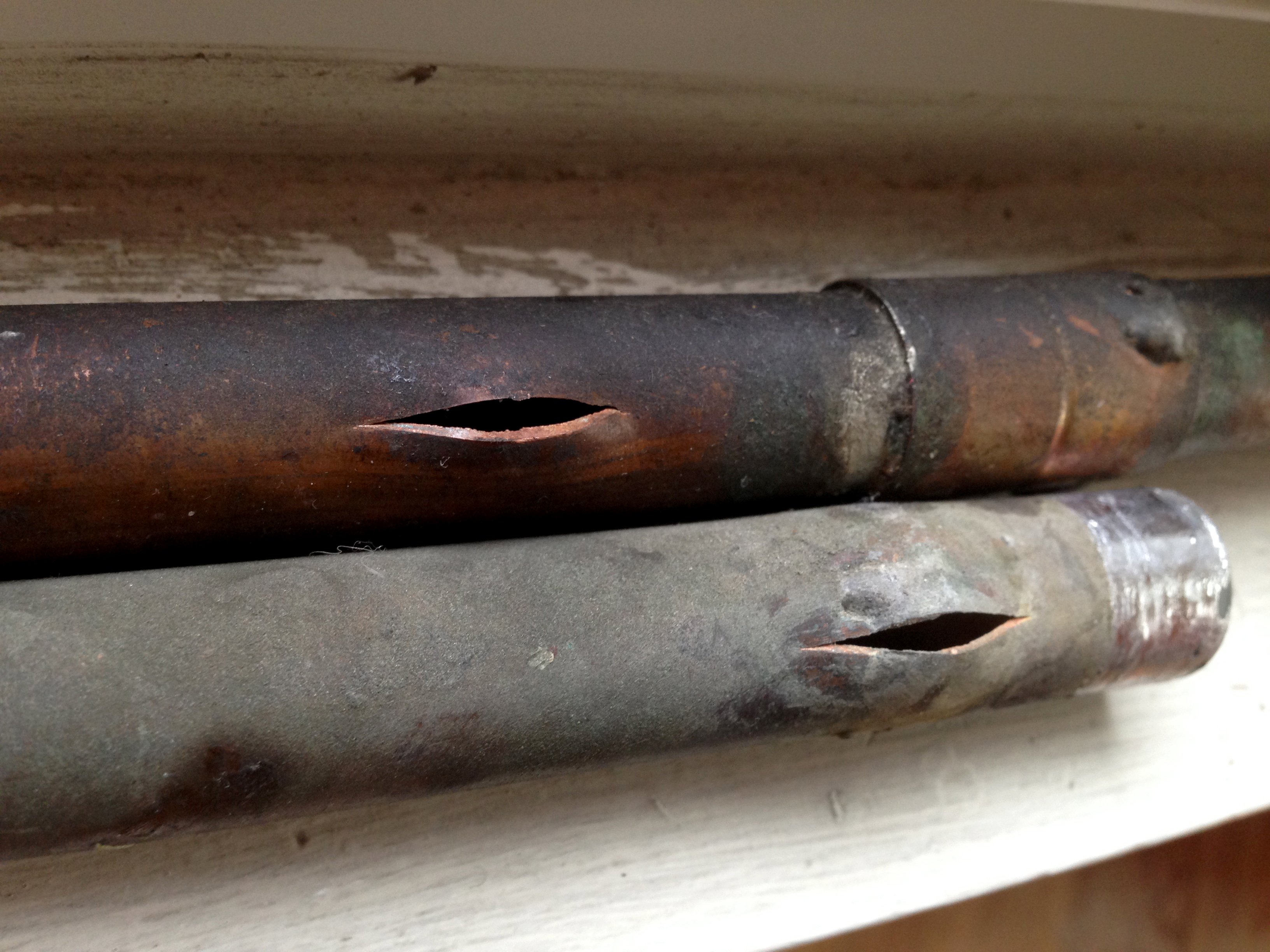 Two burst metal plumbing pipes