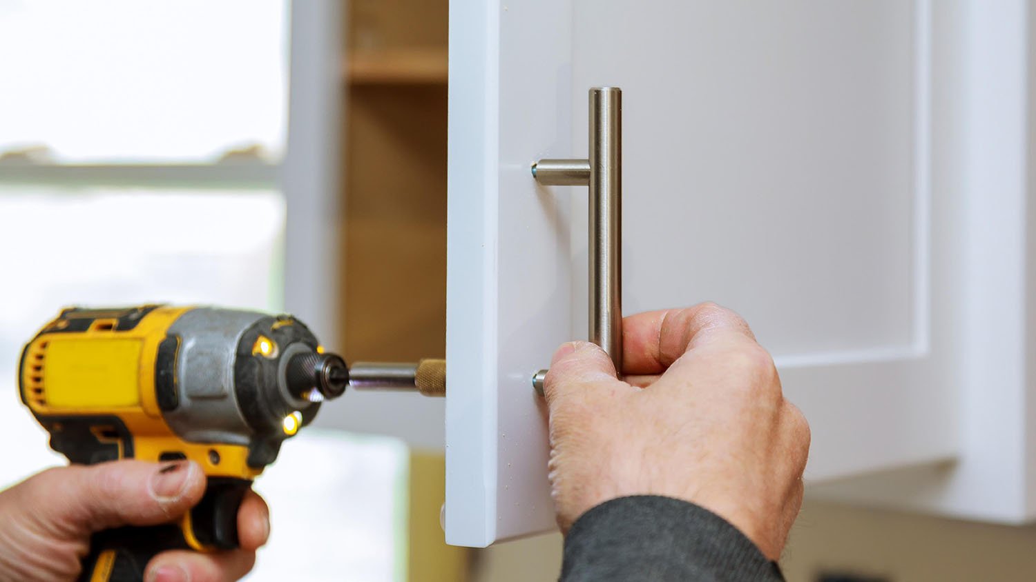 Person installing cabinet hardware