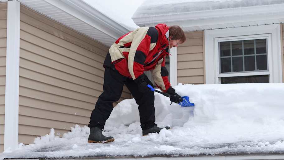 Man shoveling roof