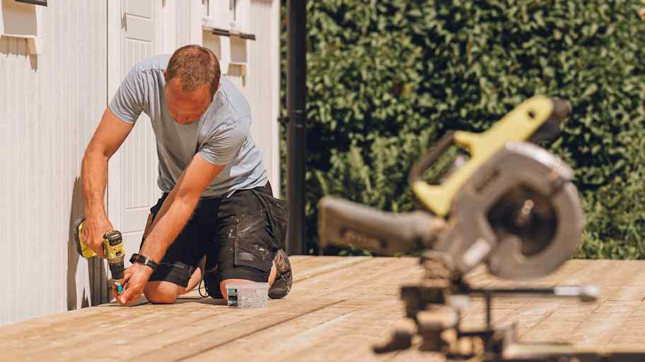Man building a wooden patio deck