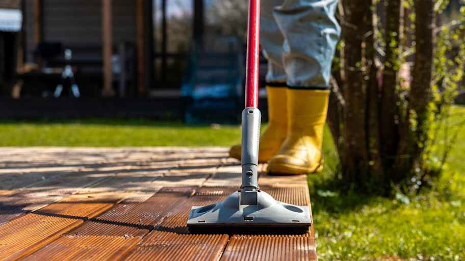 Worker applying stain to a wooden deck