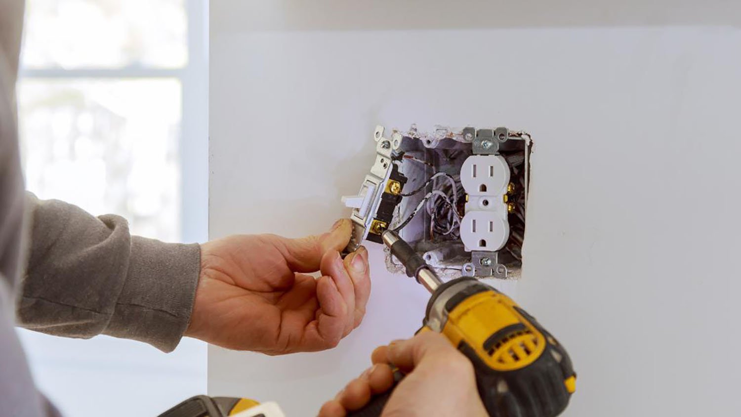 Person fixing electrical outlet