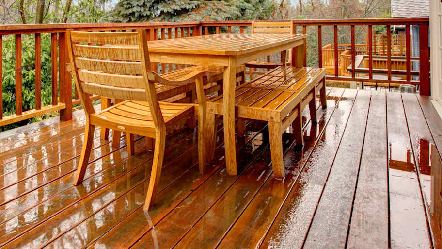 Wet wooden deck with outdoor furniture  