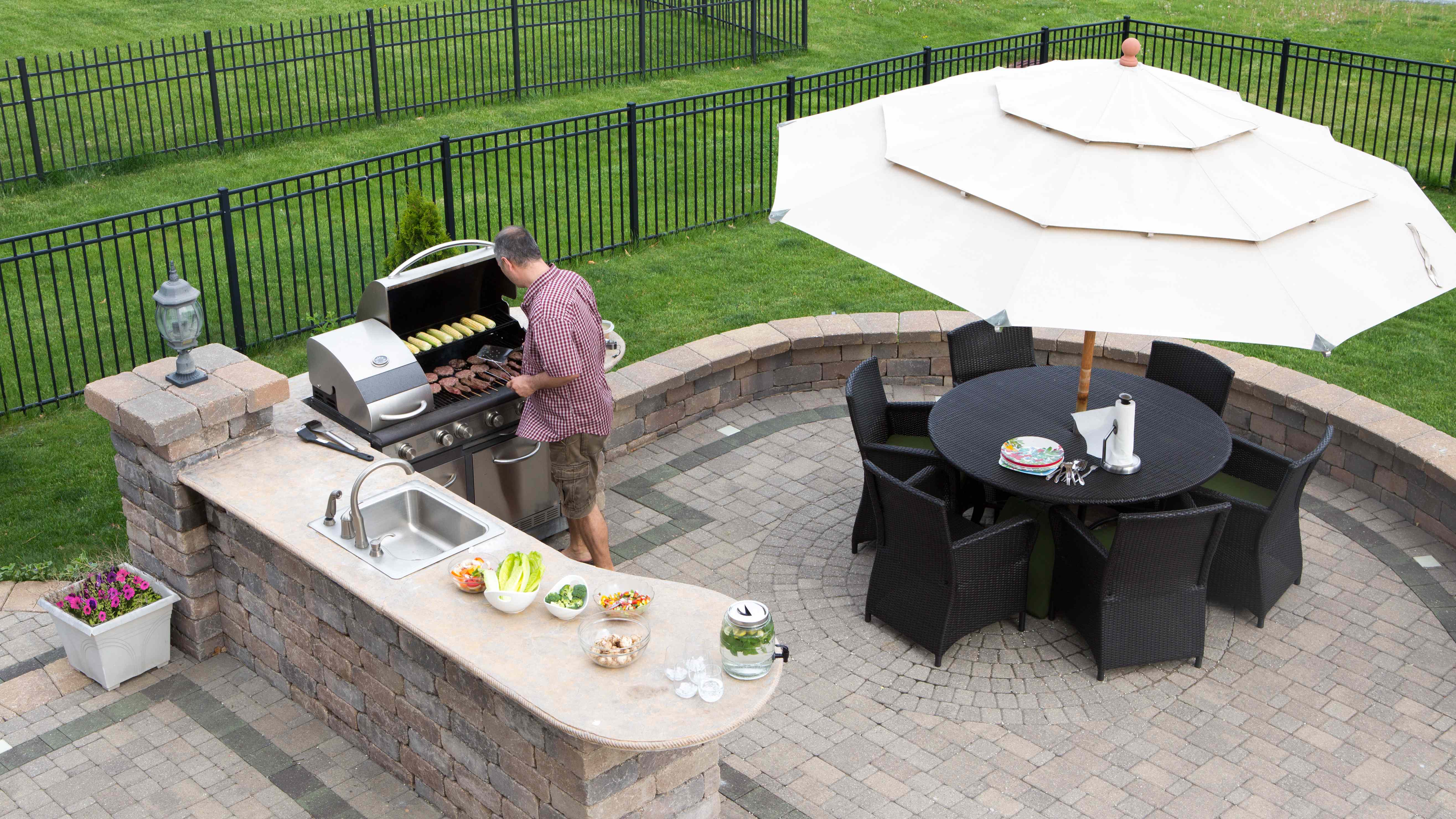 Man grilling burgers and enjoying his outdoor kitchen  