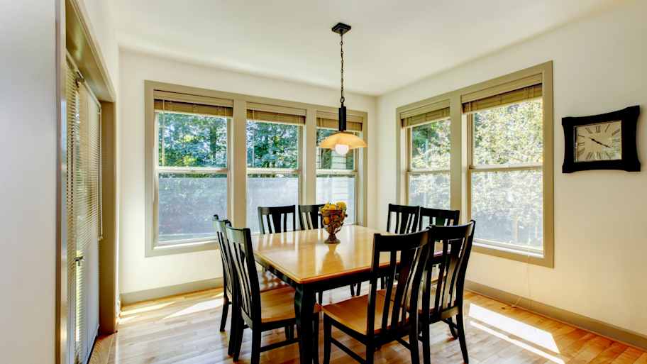 Double hung windows installed in a dining room with wooden flooring 