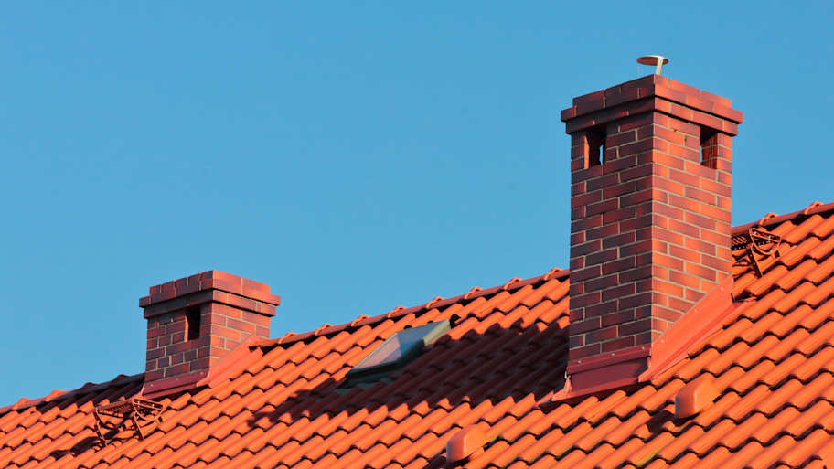 A double red brick chimney on a roof