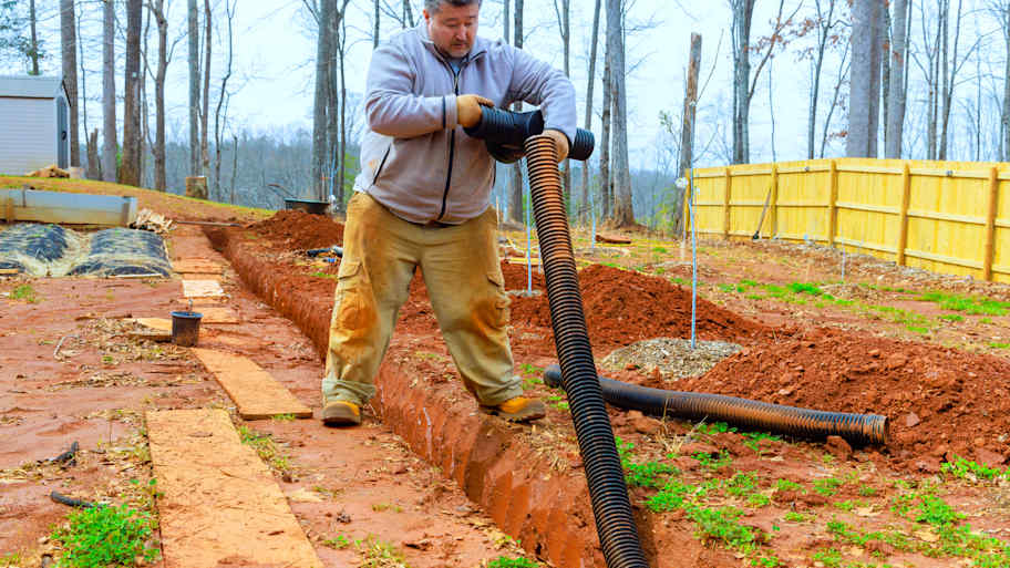 man installing drainage system 