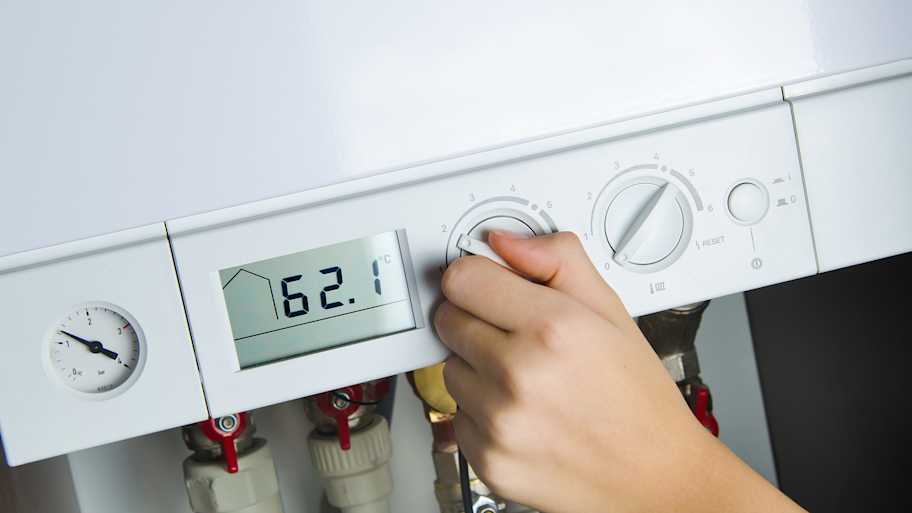 woman adjusting heat pump thermostat