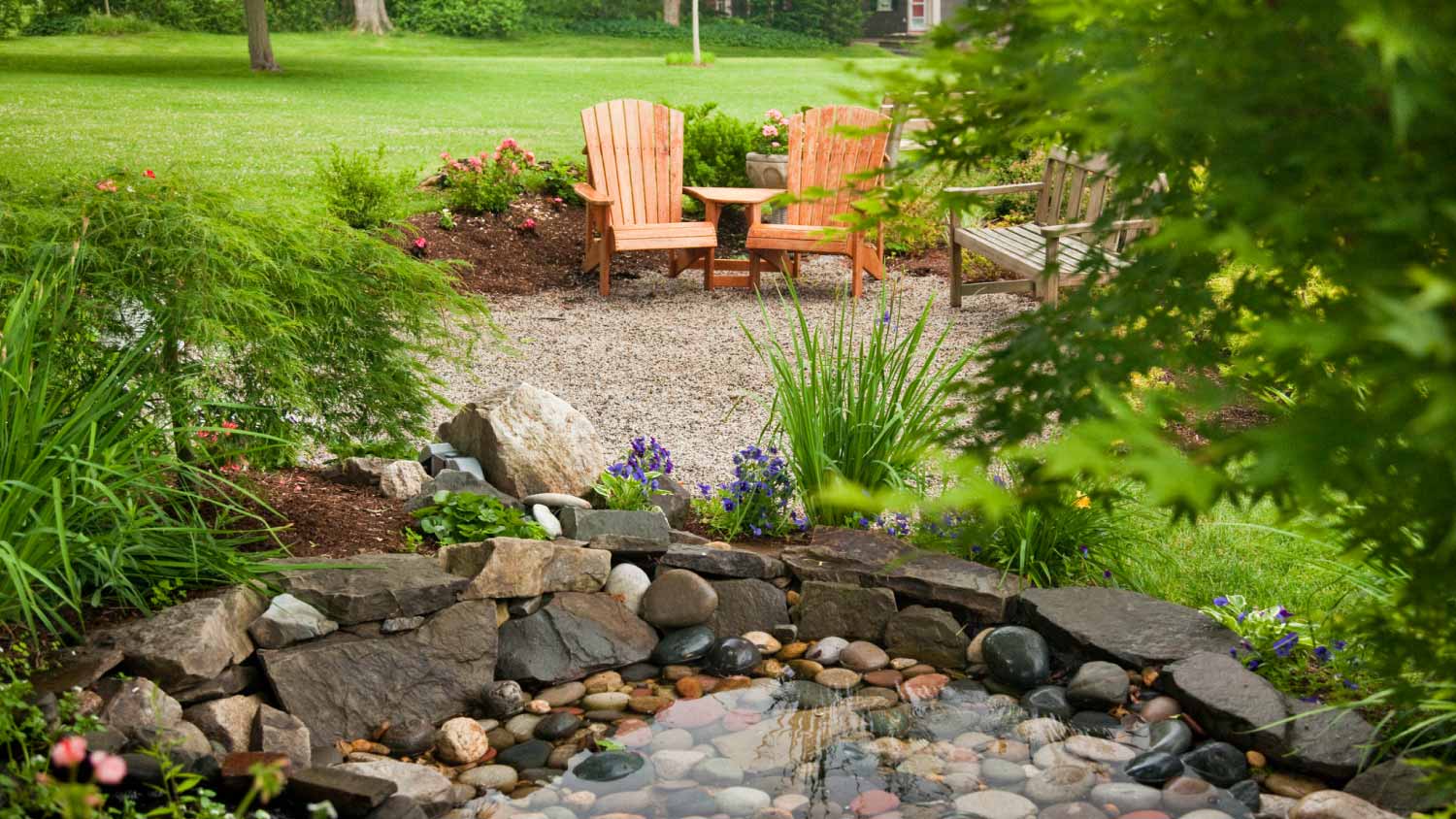 Backyard water garden with two chairs