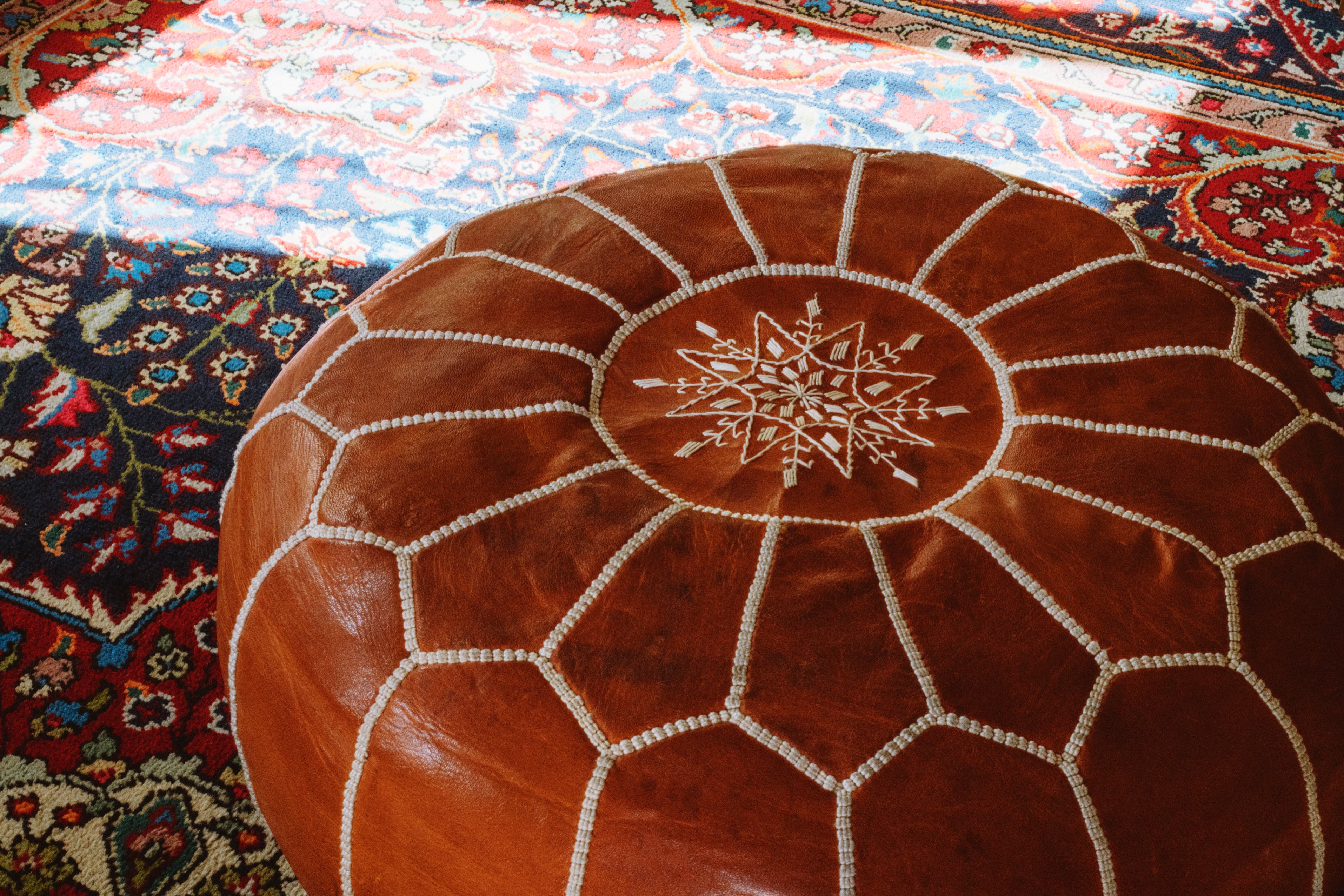 Brown leather ottoman on rug