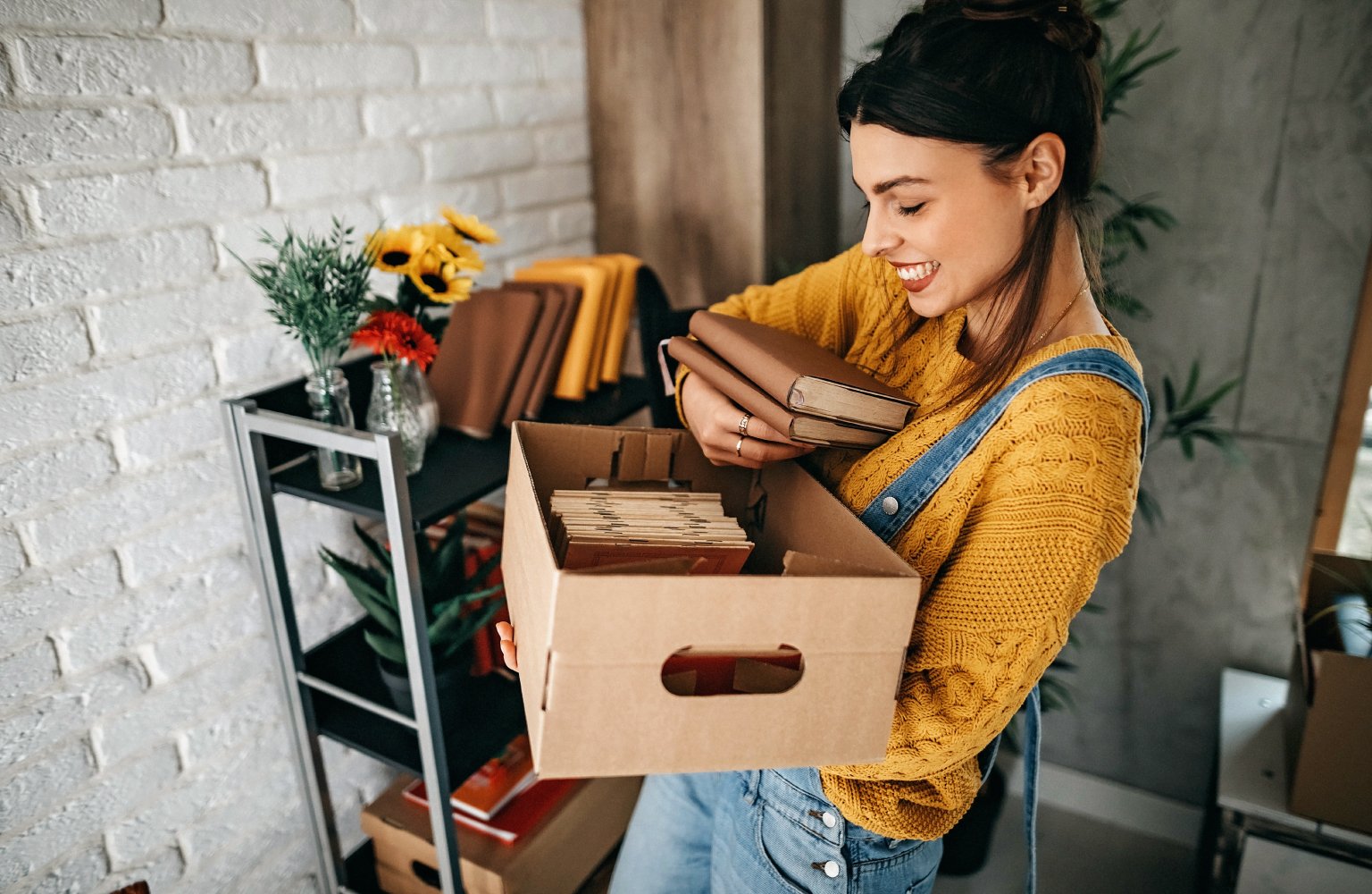 woman holding box full of books