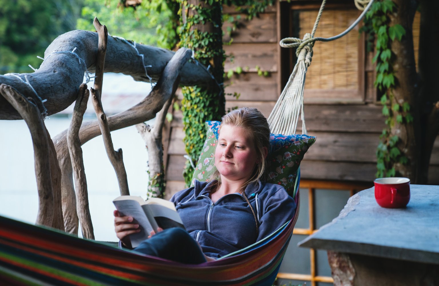 woman reading book in hammock 