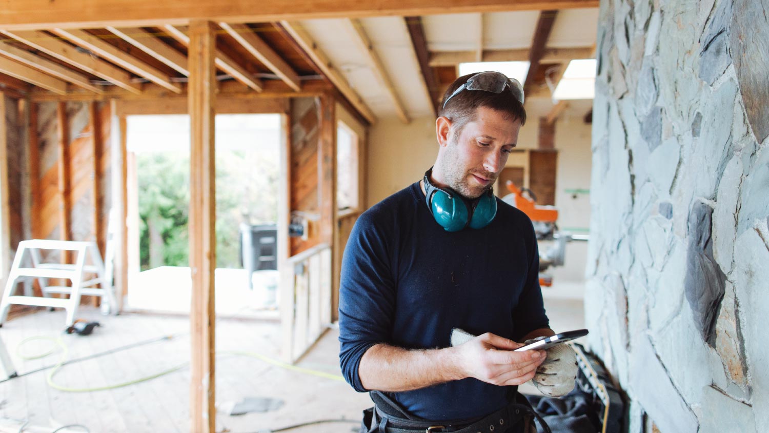 Carpenter contractor texting on cell phone