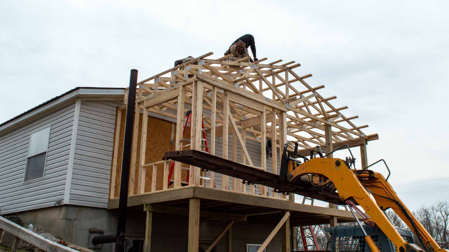 Carpenters on the roof of new building addition