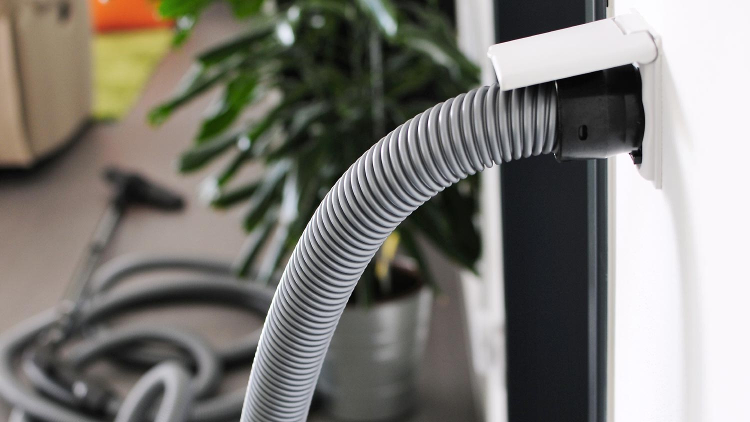 A central vacuum cleaner hose plugged in to wall