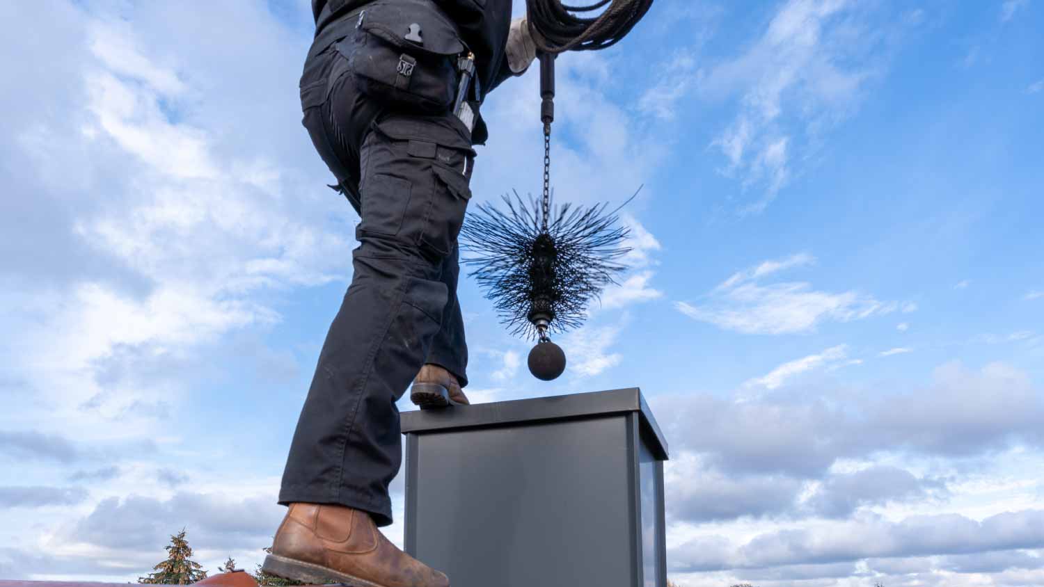 Chimney sweep cleaning a chimney