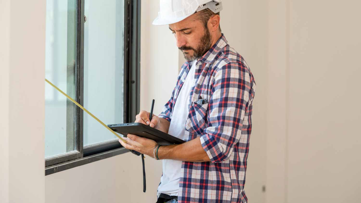 Construction supervisor writing on digital tablet