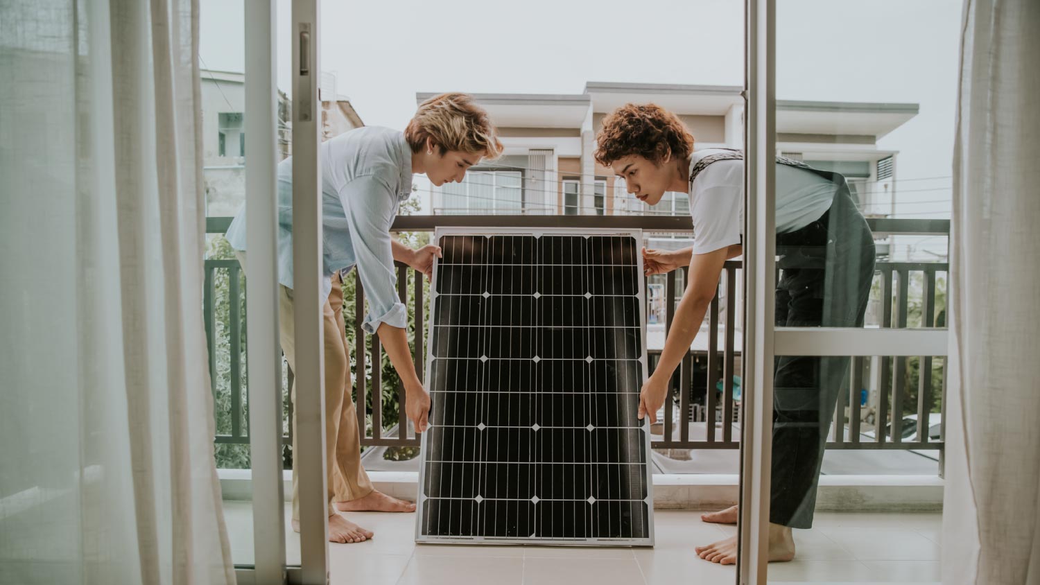 Couple installing solar panel on balcony