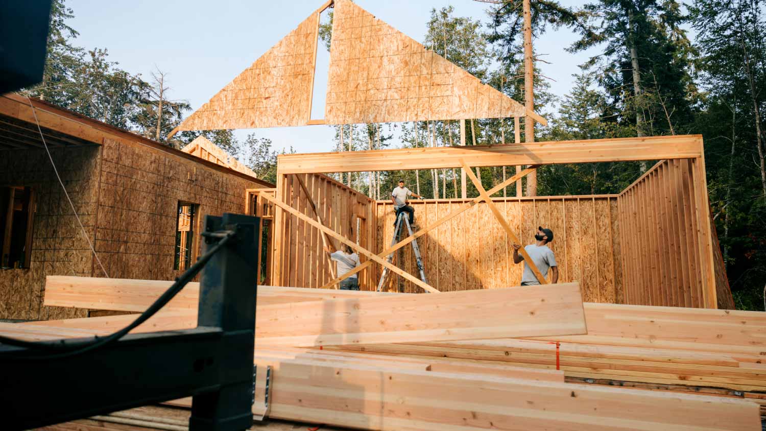 Crew putting up framing of new home 