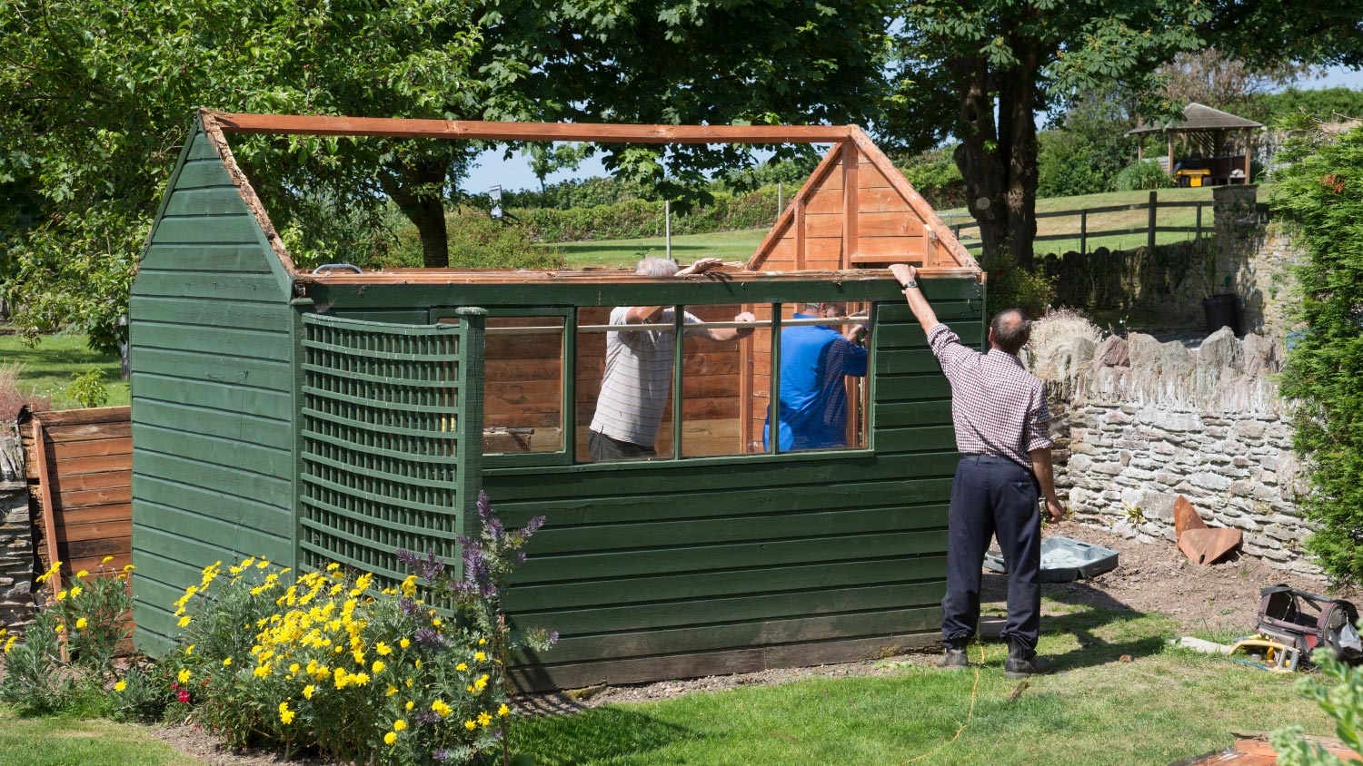 Men demolishing a garden shed