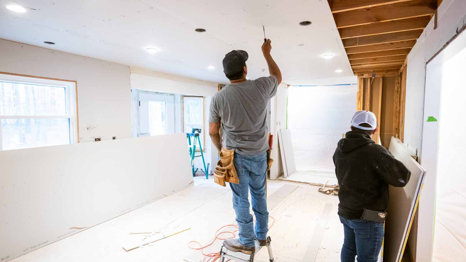 Drywall installers working in kitchen renovation