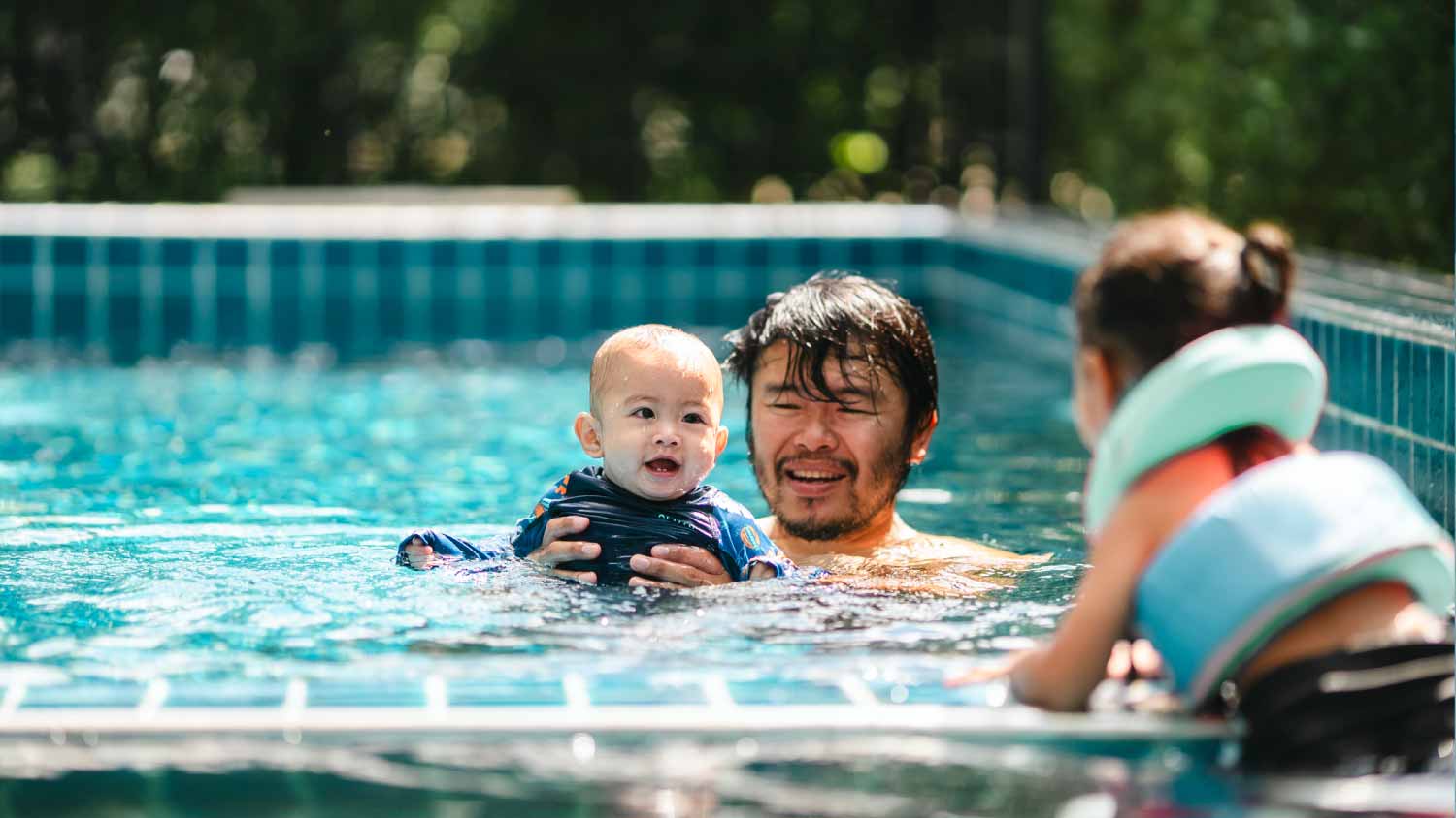 Family playing in the pool
