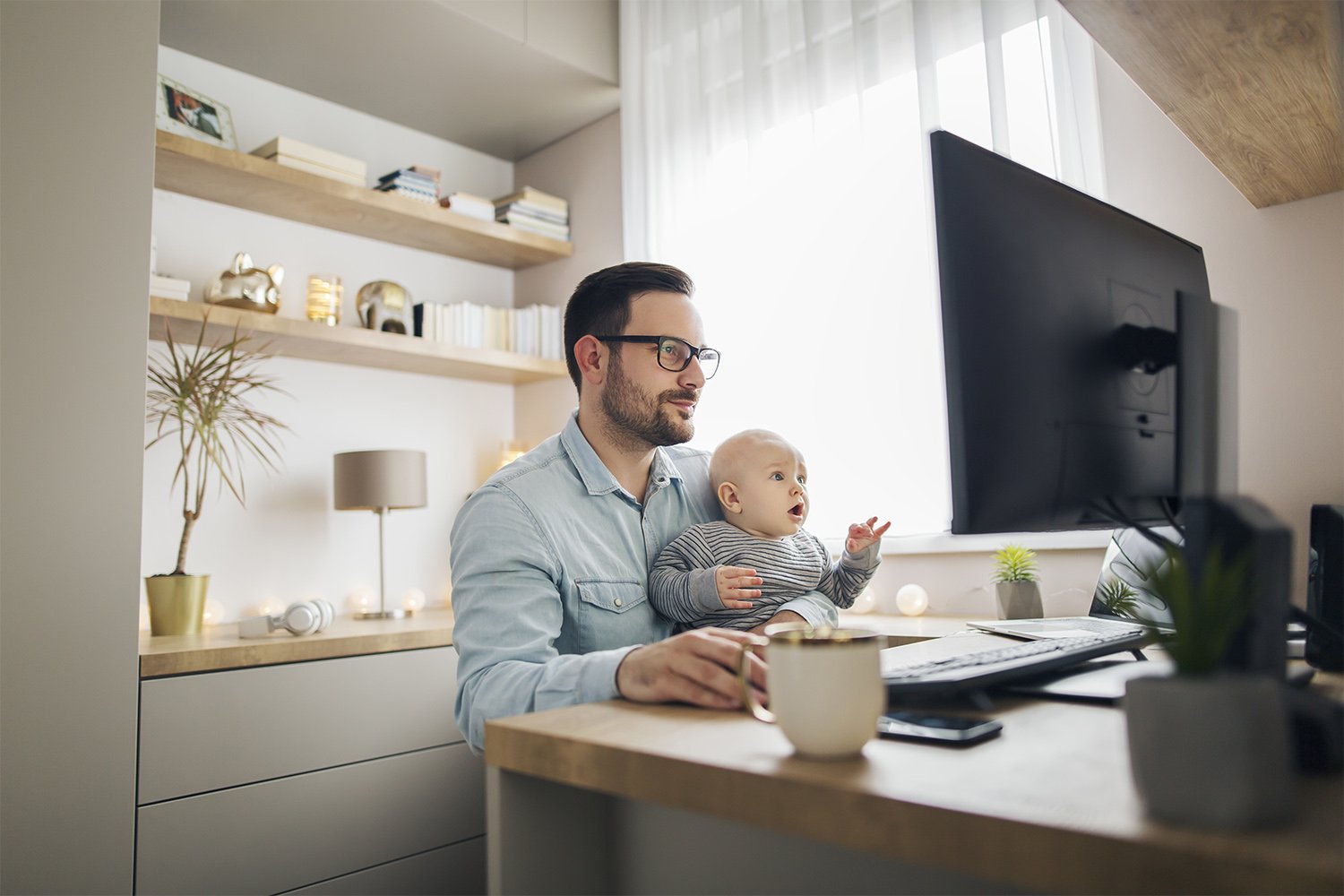 Father and kid sitting at computer in home office