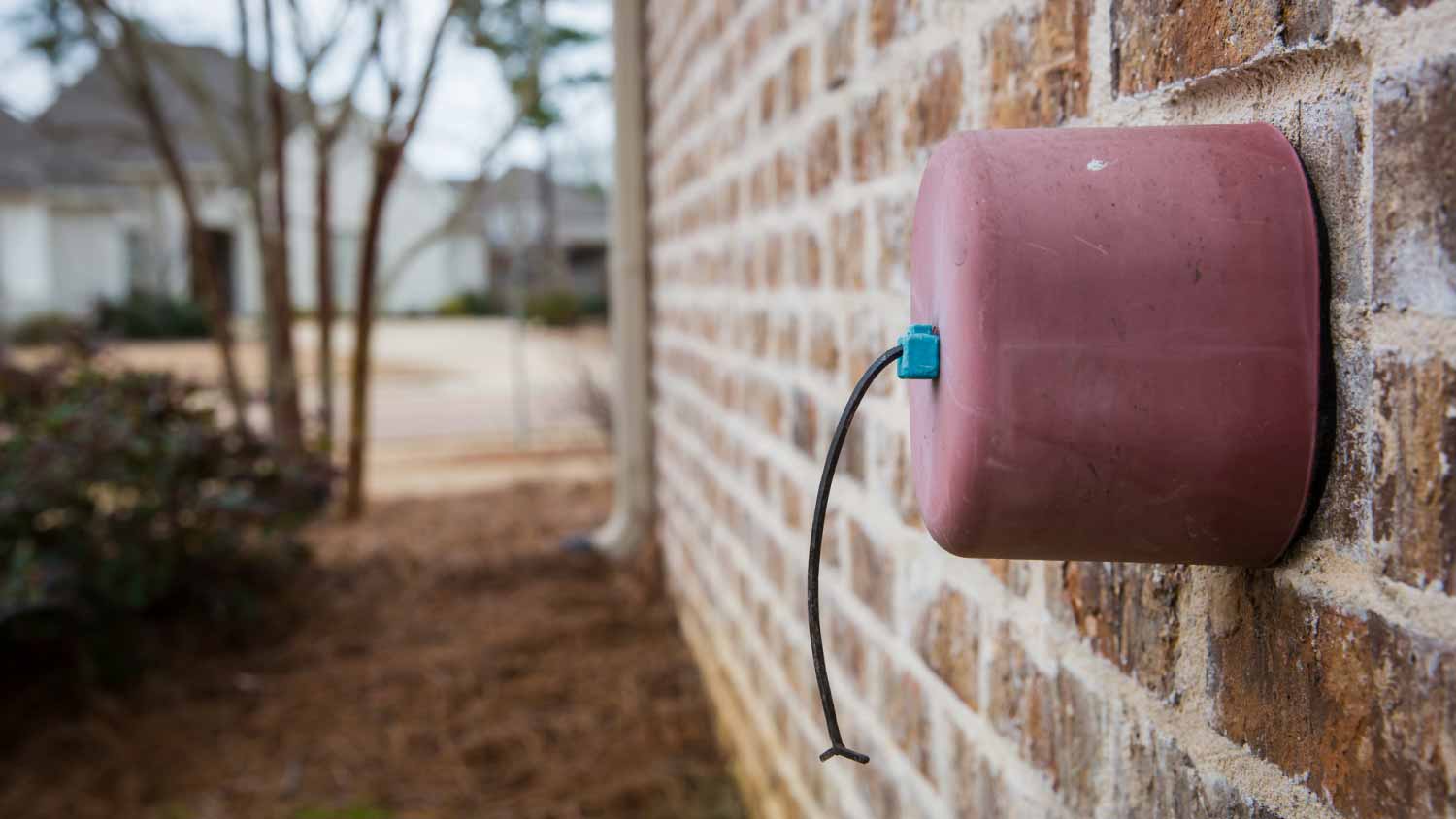 Faucet cover on exterior brick wall