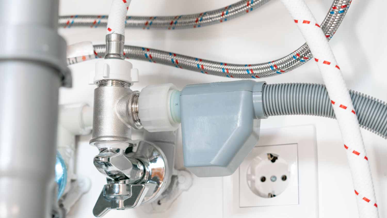 White and gray pipes under a kitchen sink