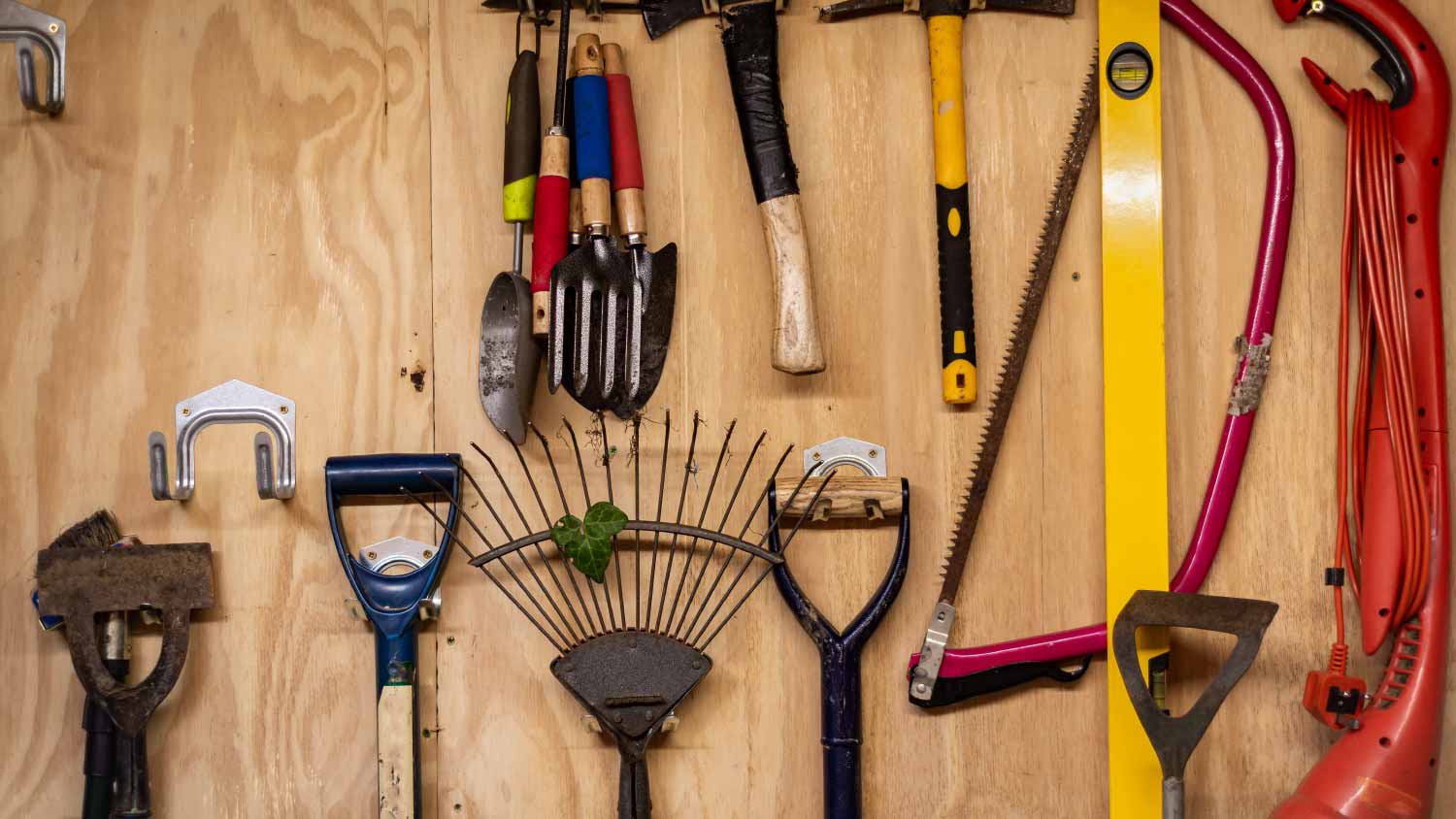 Gardening tools hanging on wooden