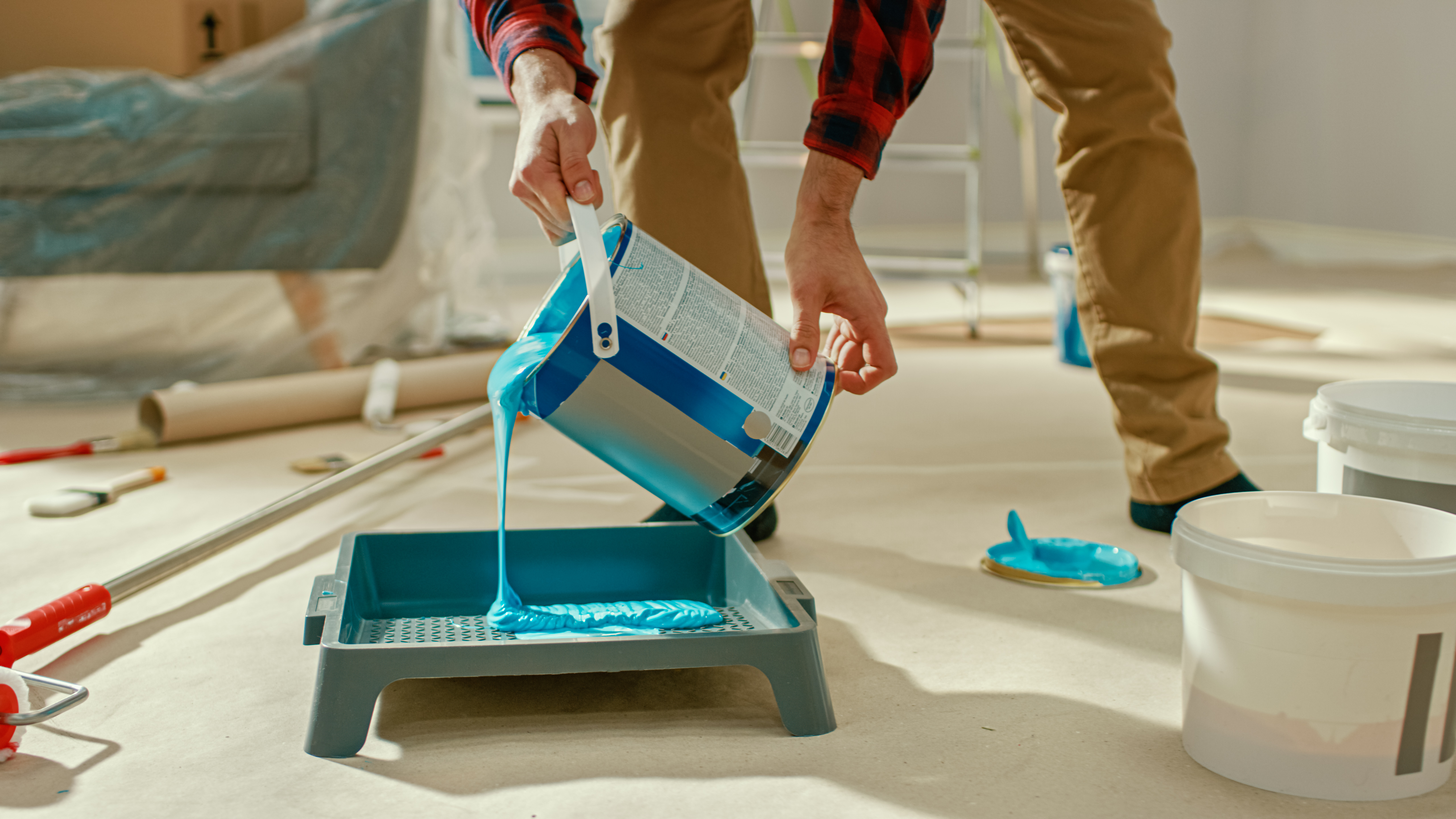 Man pouring paint into tray