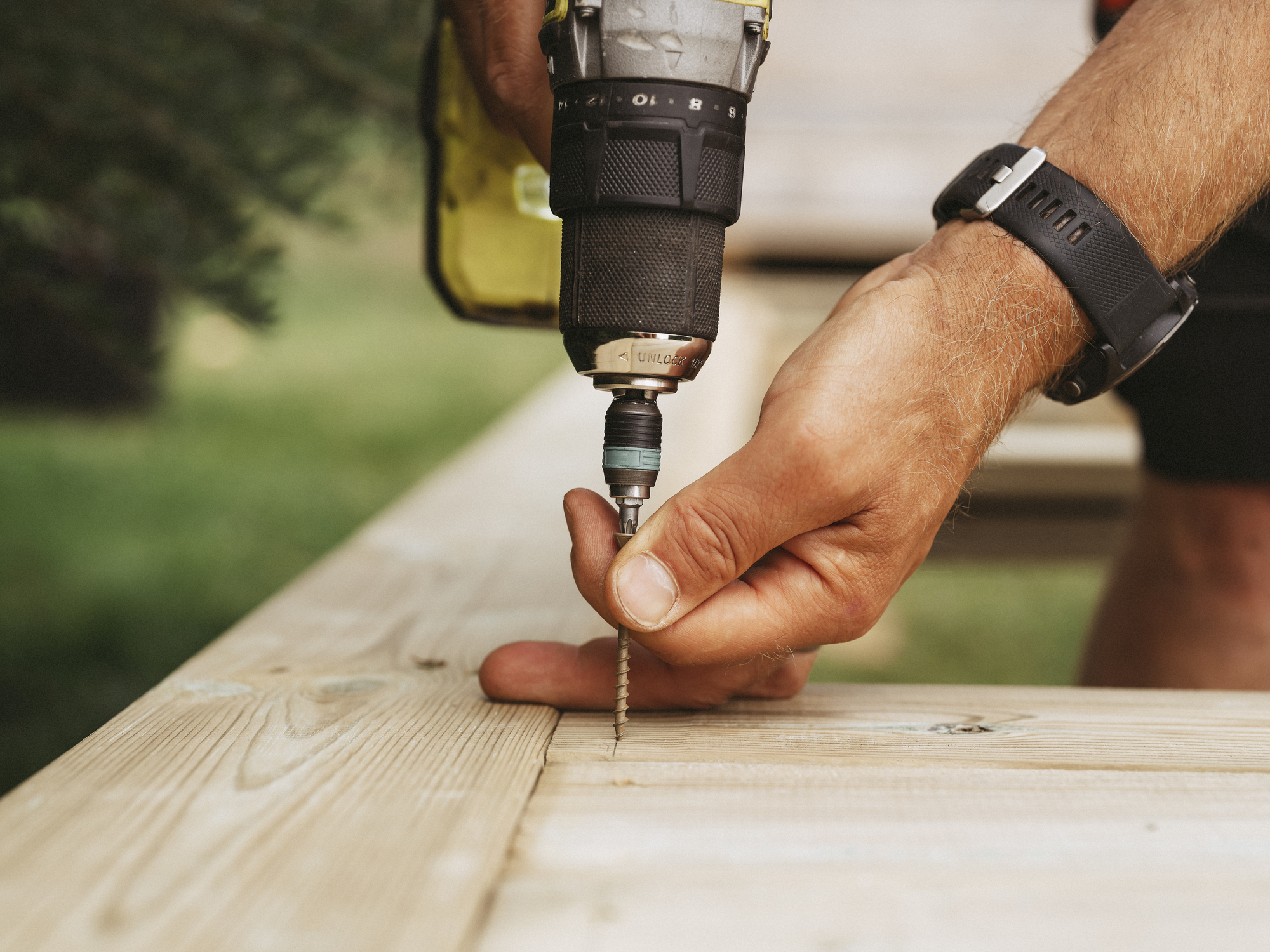 Worker using power to install a floorboard