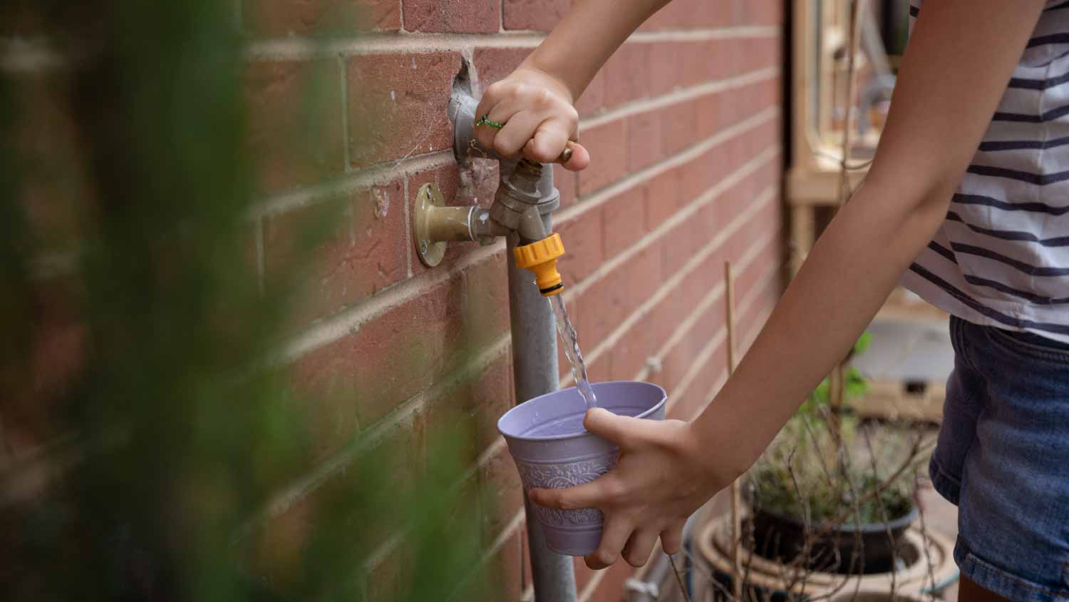 Girl filling a decorative metal pot