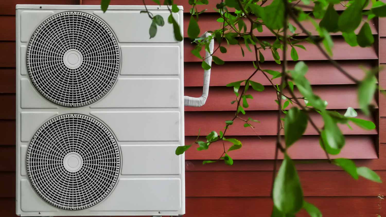 Heat pump next to a red wall