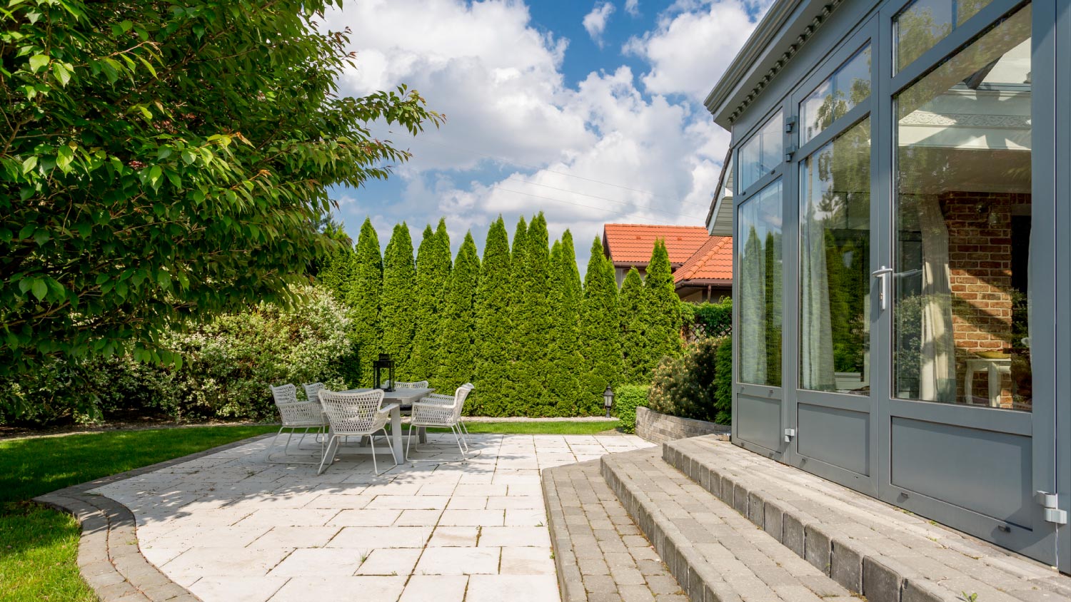 A house exterior with terrace and trees