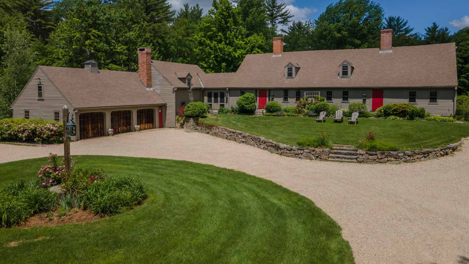 House with tall trees behind with a driveway