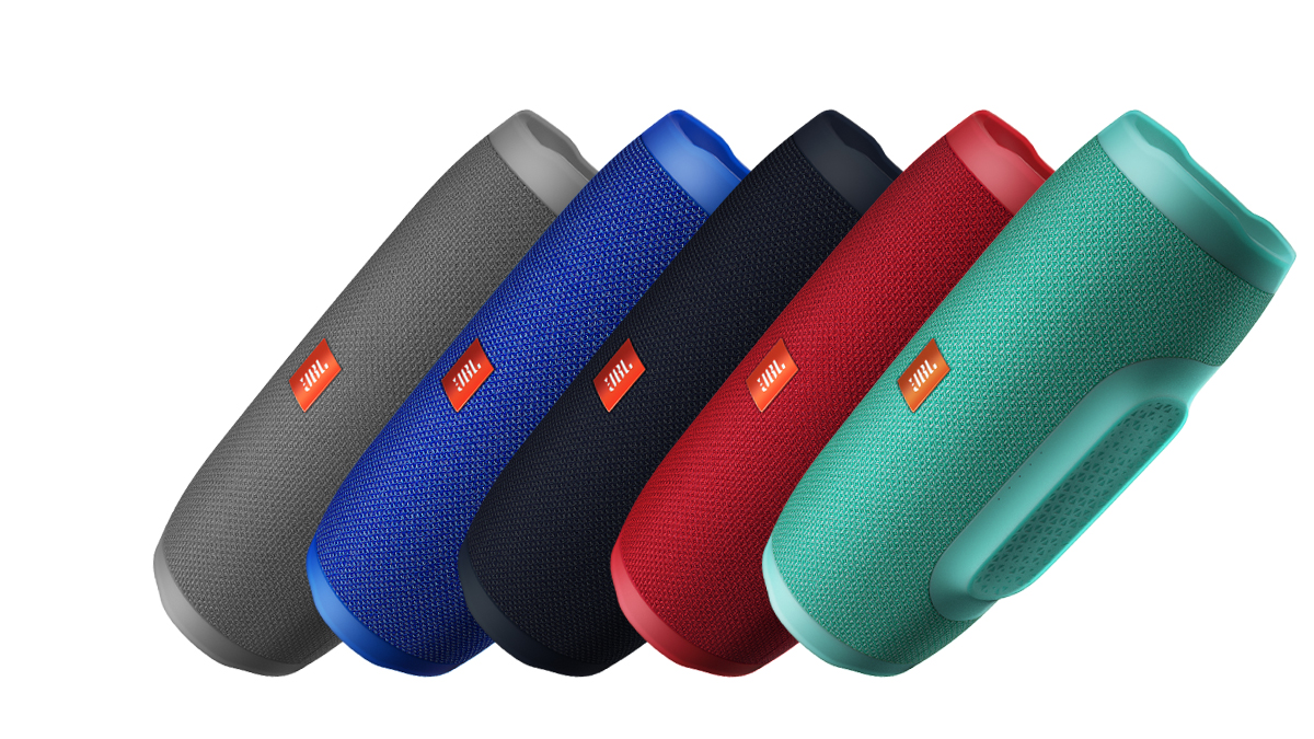 Product shot of four JBL Charge 3 waterproof Bluetooth speakers, one each in grey, blue, black, red and teal.