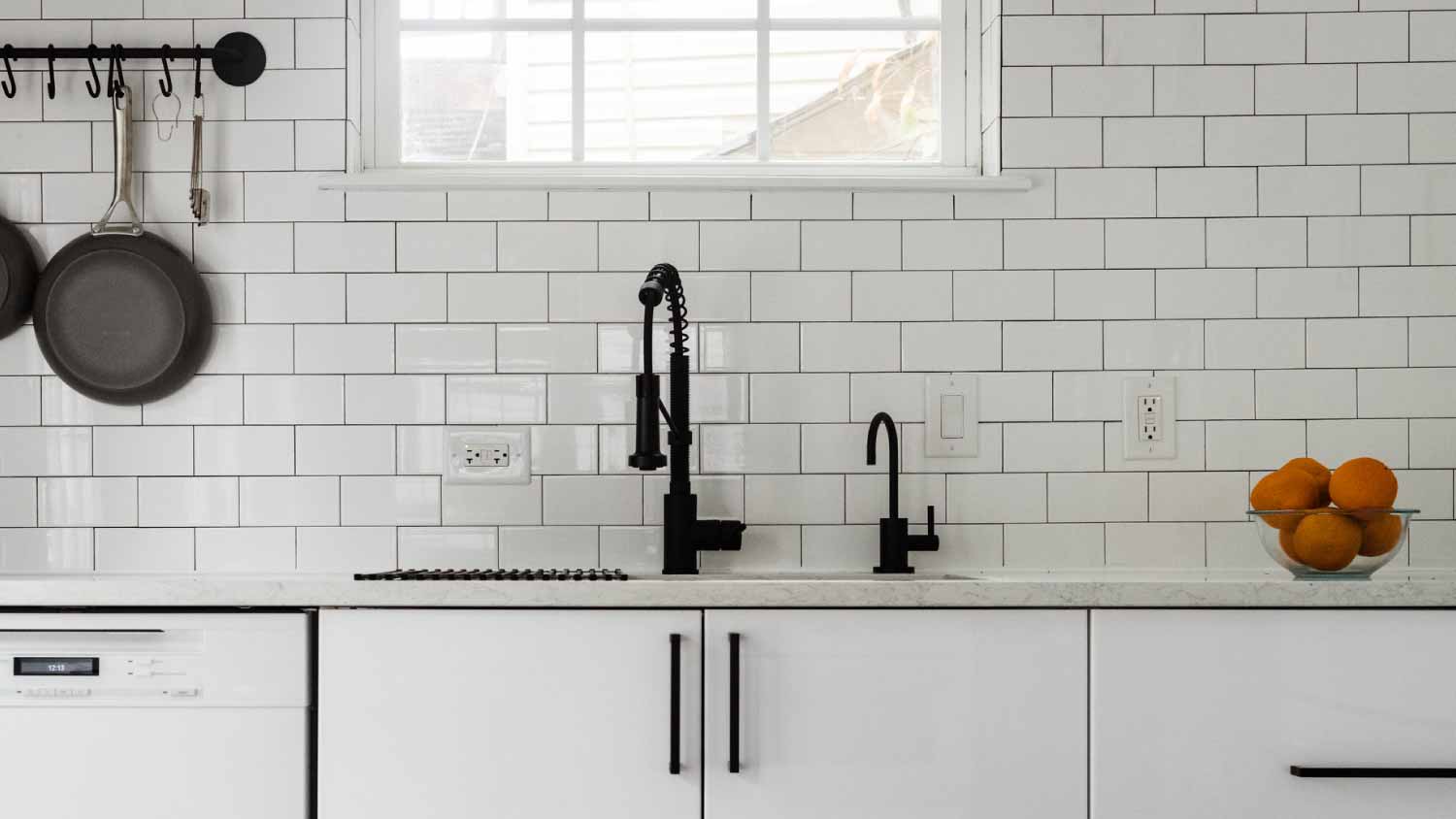 Kitchen sink and white tile backsplash 