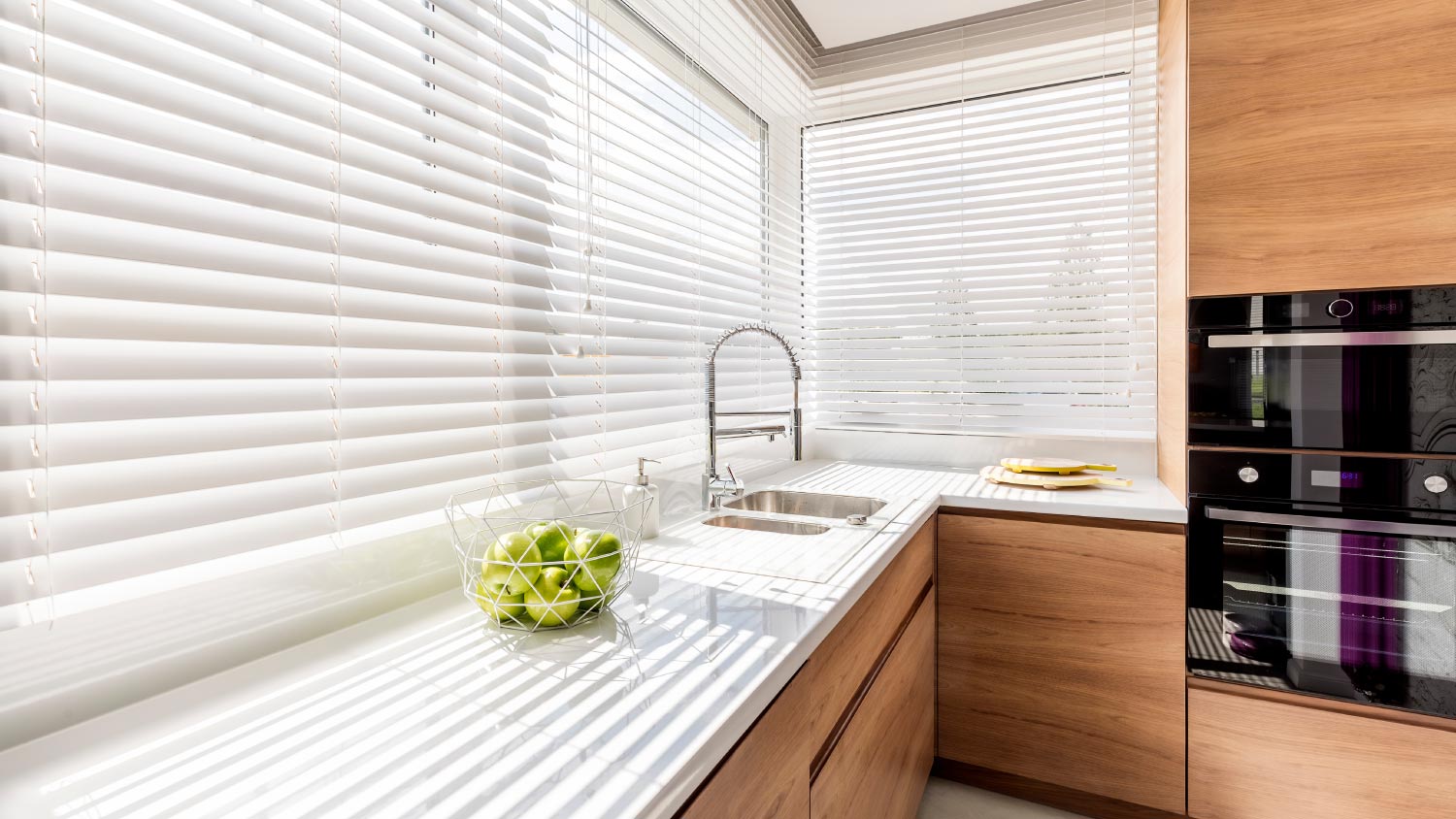 A kitchen with white window blinds