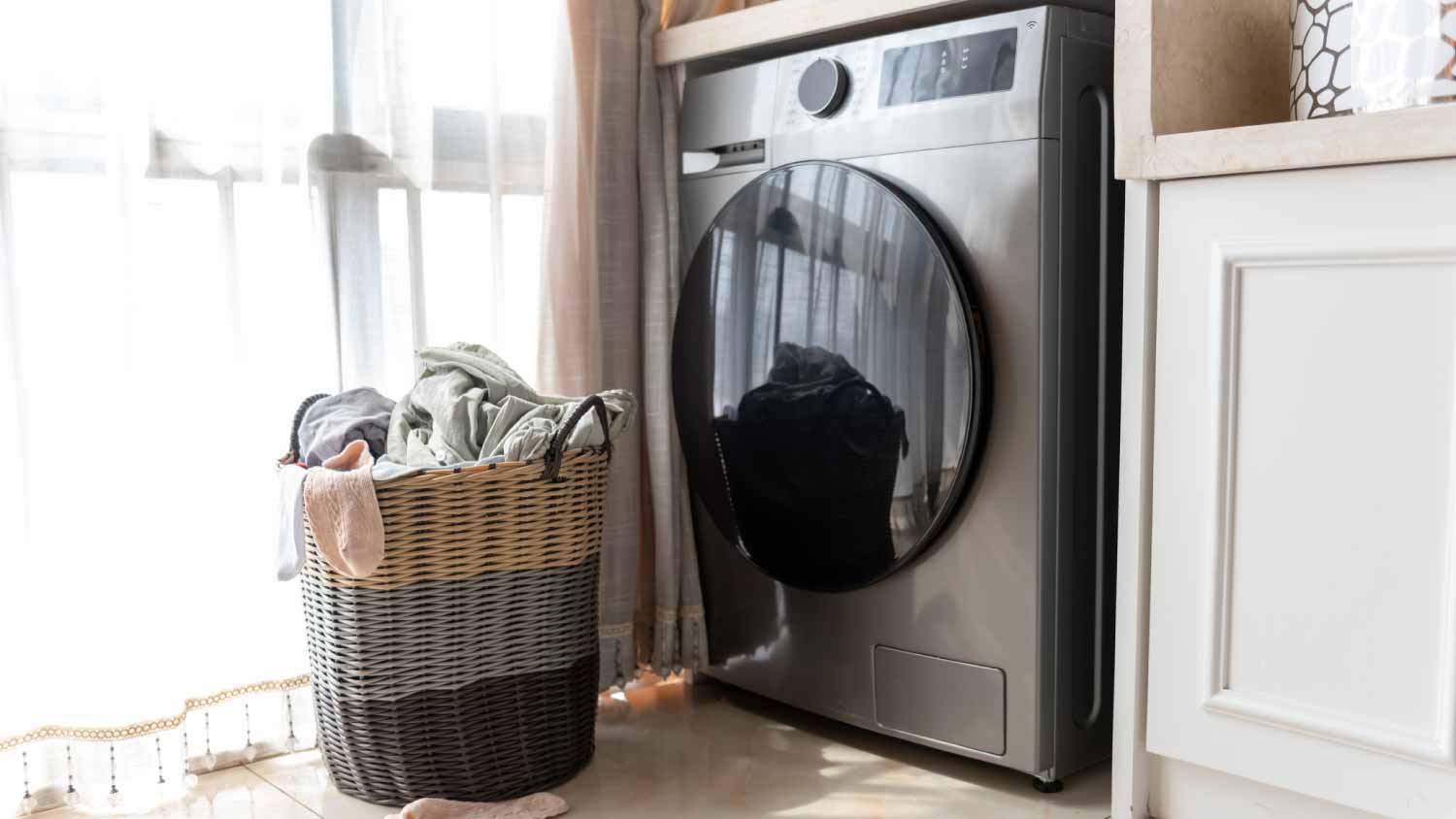 Laundry basket of clothes near washing machine