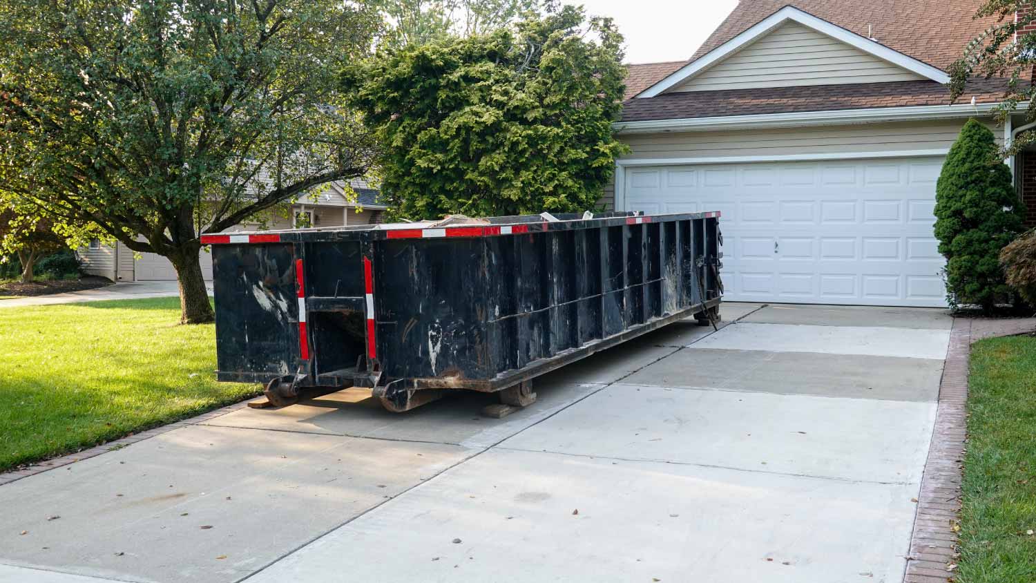 Long dumpster in front of a house