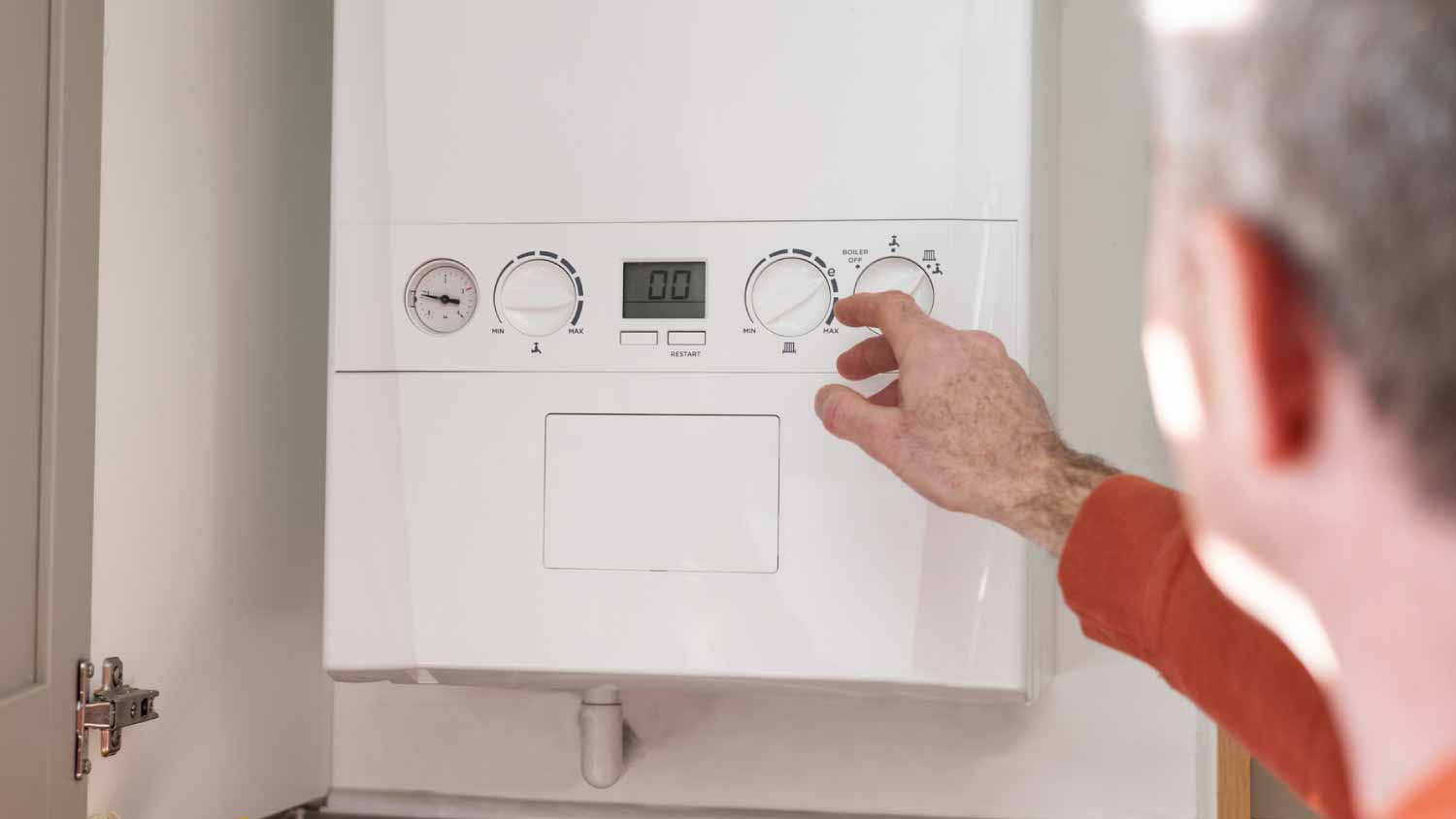 Man adjusting boiler in kitchen